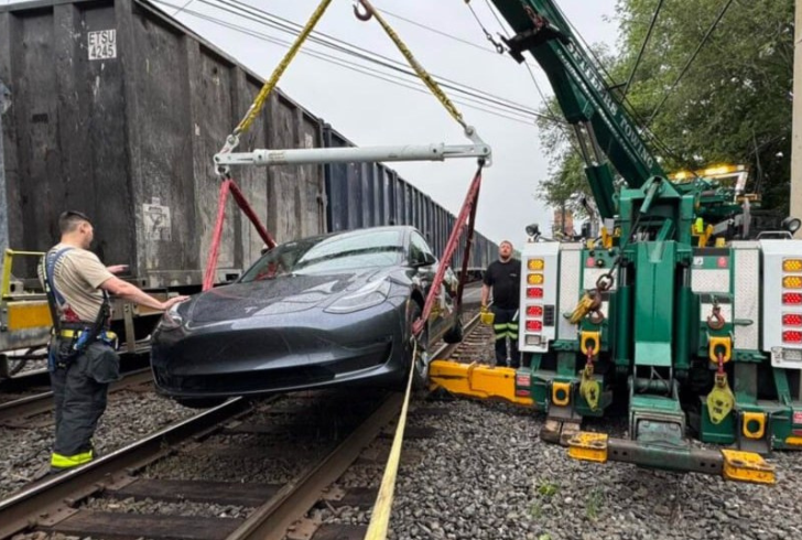 Tesla car towing at railway crossing
